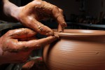 hands of a potter, creating an earthen jar on the circle